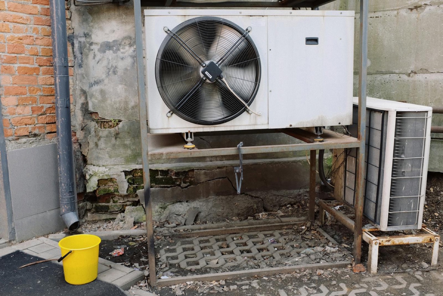 Weathered, corroded outdoor AC condenser coil with rust damage