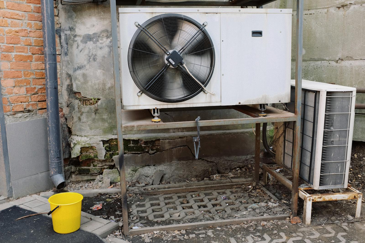 Weathered, corroded outdoor AC condenser coil with rust damage