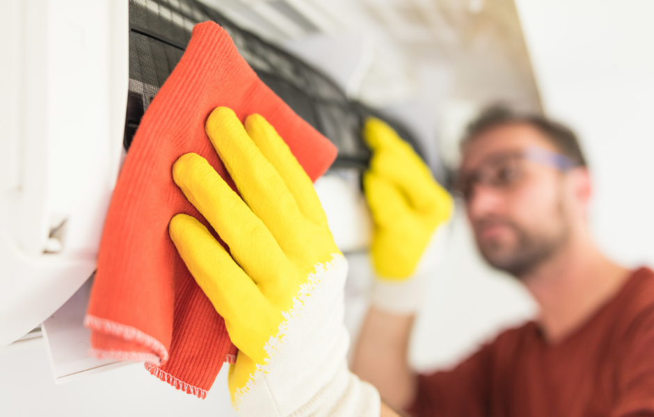 Homeowner cleaning an indoor AC unit filter