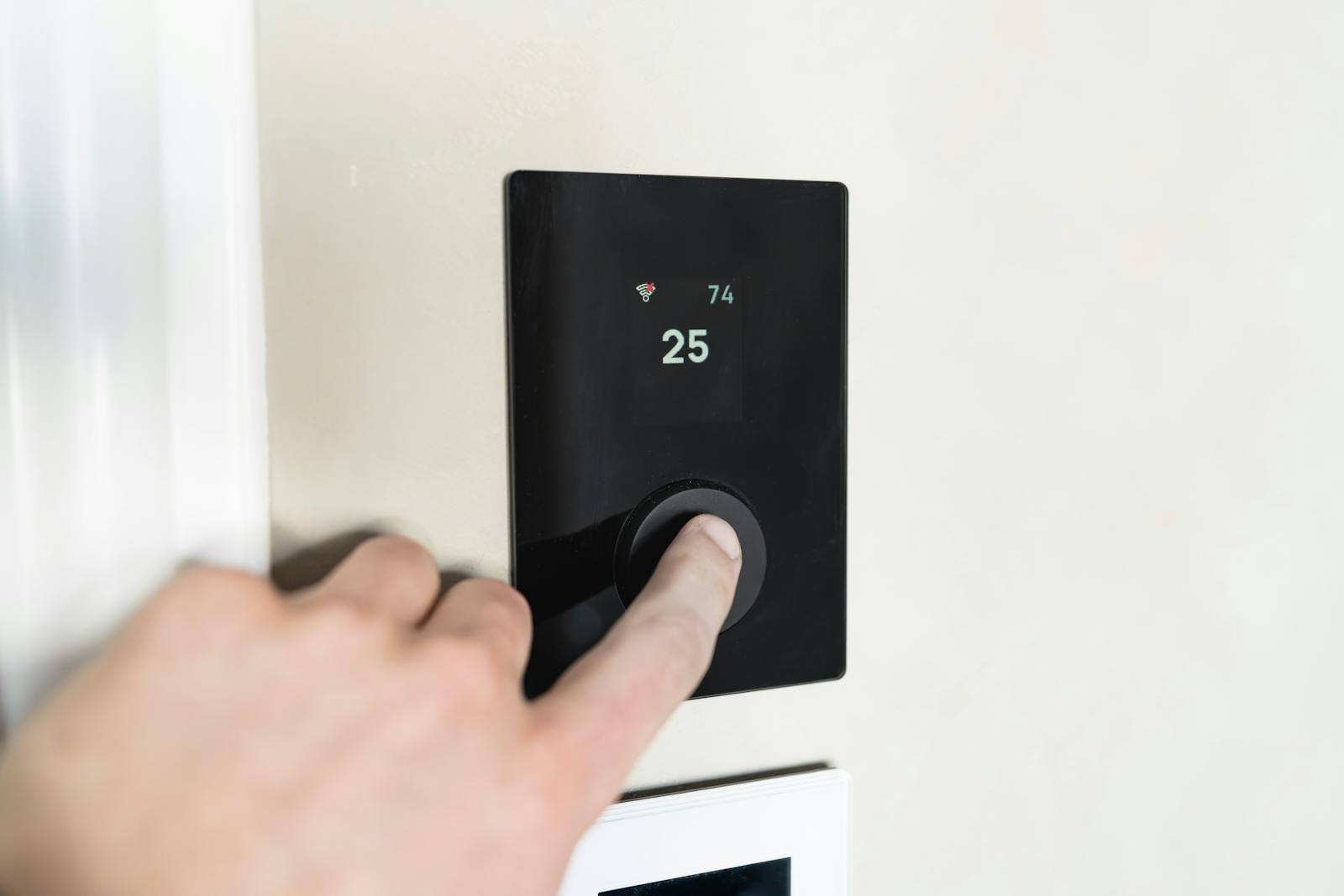 Hand adjusting a smart thermostat on a Florida home wall